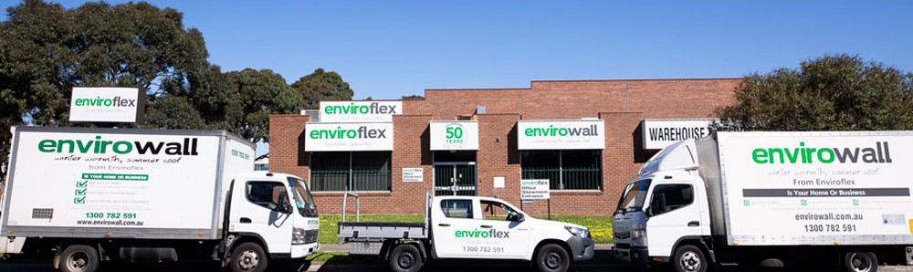 Enviroflex warehouse with company signage and three branded vehicles, including two trucks and a ute, parked in front.